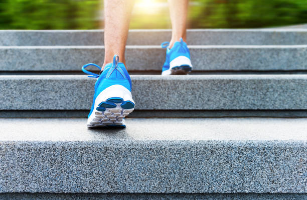 Low section of young man climbing up stairs