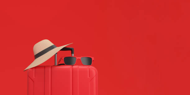 istock Panoramic of Suitcase with sun glasses and hat on red background. Exotic Vacation concept. 1487307538