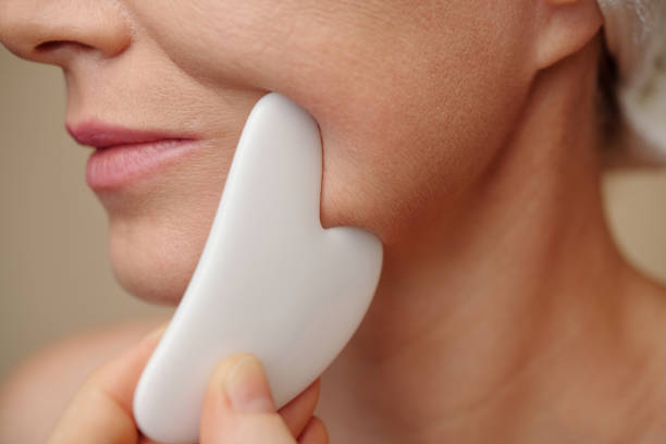 istock Woman Massaging Face with Gua Sha 1487308346