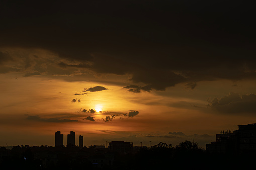 in silhouette city during sunset with stormy cloud