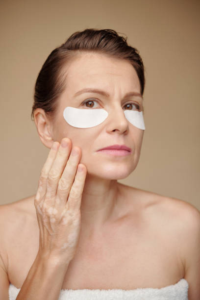 istock Woman Applying Brightening Patches 1487309122