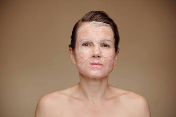 Portrait of mature woman with moisturizing sheet mask on face