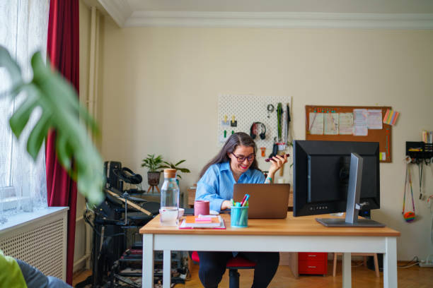 istock Woman using mobile phone and digital tablet at home office 1487310024