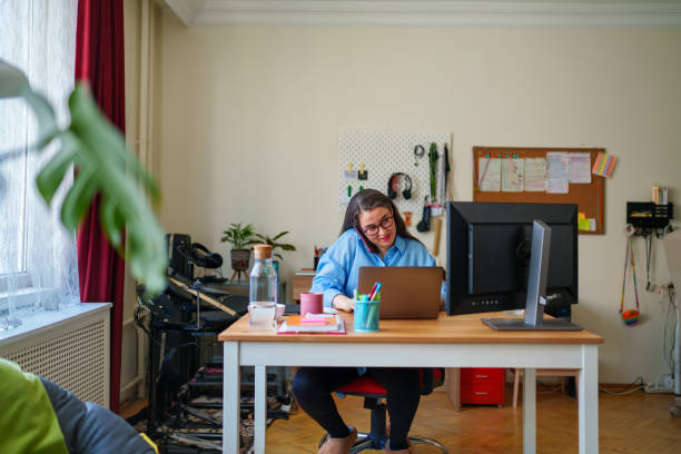 istock Woman using mobile phone and digital tablet at home office 1487310032