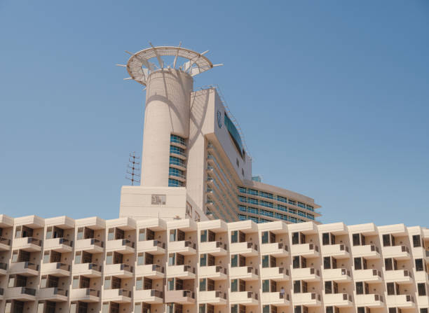 Abu Dhabi, UAE - March 19, 2023: Abu Dhabi Mall and Beach Rotana Hotel. View from the water, of the Beach Rotana Hotel and the Abu Dhabi Mall, with reflections.