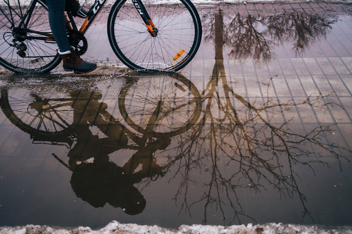 One person is riding a bike in a puddle in a public parc of Montreal, Quebec.