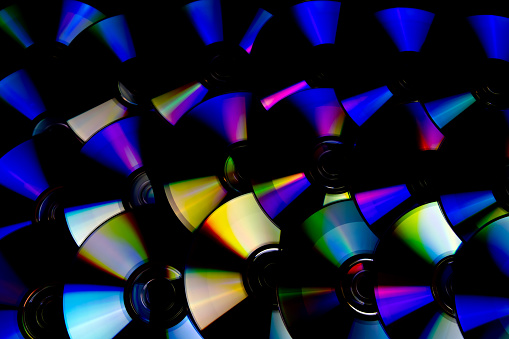 CD and DVD isolated on black background with colorful light reflections