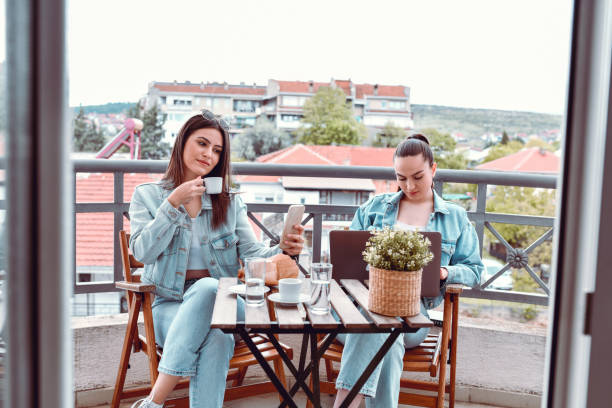 istock Two Cute Females Using Technology While Enjoying Afternoon Coffee Together 1487313278