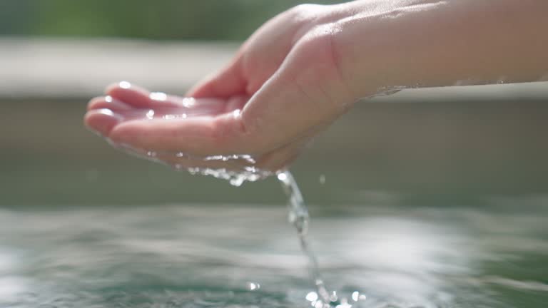 Unknown young woman scoops up glassy water