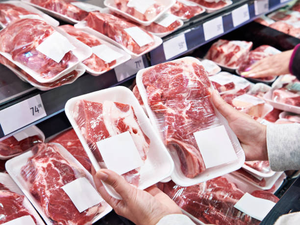 Hand with beef meat in shop stock photo