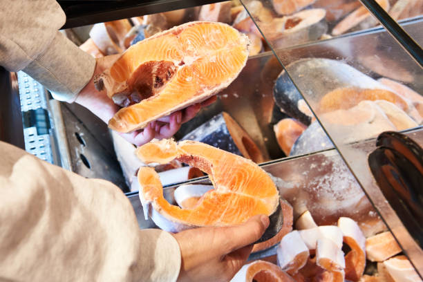 istock Buyer hand with frozen red salmon fish 1487313717