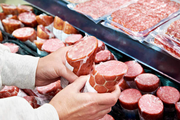 istock Sliced sausage in hands in store 1487314362