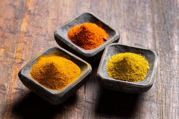 istock Turmeric, pepper and curry powder in container on wooden background 1487315187