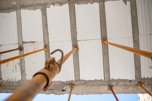 Construcción de la casa, puntales de hierro soportan el marco del techo, mientras que los conjuntos de cemento, puntales de hierro photo