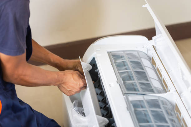 técnico instalando un aire acondicionado en la casa de un cliente, joven reparador arreglando la unidad de aire acondicionado, conceptos de mantenimiento y reparación - air conditioner electricity repairing furnace fotografías e imágenes de stock