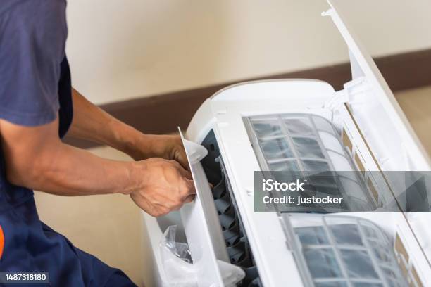 Technician Man Installing An Air Conditioning In A Client House Young Repairman Fixing Air Conditioner Unit Maintenance And Repairing Concepts Stock Photo - Download Image Now
