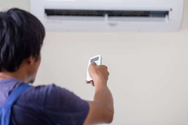 istock Air conditioner inside the room with technician operating remote controller, Repairman fixing air conditioner unit, Maintenance and repairing concepts 1487318188