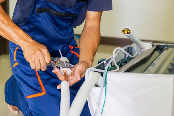 istock Technician man installing air conditioning in a client house, Young repairman fixing air conditioner unit, Maintenance and repairing concepts 1487318321