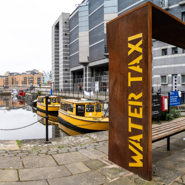 water taxi sign and boats at leeds dock quayside - leeds england yorkshire canal museum imagens e fotografias de stock
