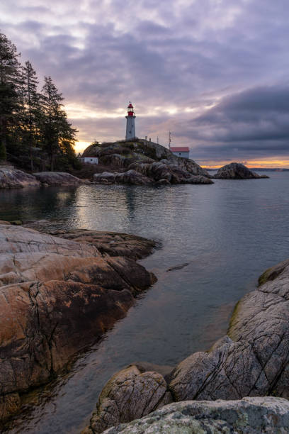 istock Sunrise over a tall lighthouse situated on a rugged rocky coast 1487319488