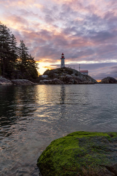 istock Sunrise over a tall lighthouse situated on a rugged rocky coast 1487319489