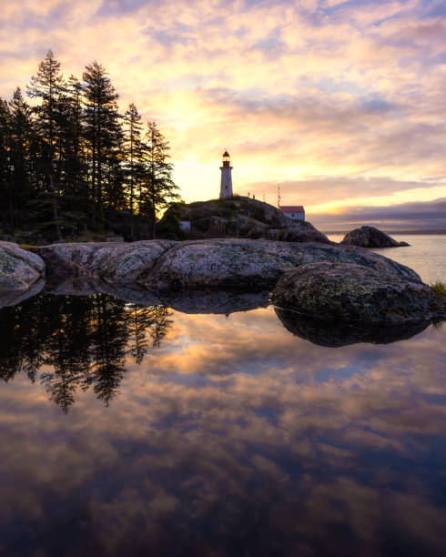 istock Sunrise over a tall lighthouse situated on a rugged rocky coast 1487319562