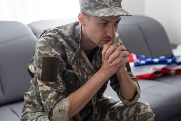 istock soldier in uniform and cap holding american flag 1487320113
