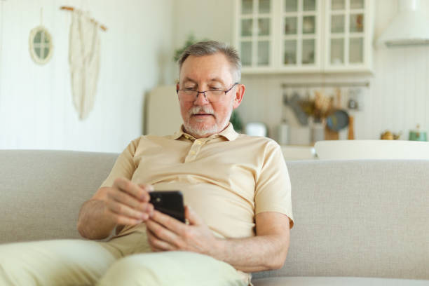 istock Happy middle aged senior man holding using smartphone touch screen typing scroll page. Stylish older mature beard grandfather with cell phone using internet social media apps at home. Shopping online. 1487320179