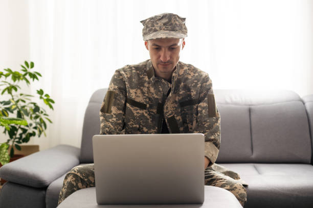 istock partial view of army soldier using laptop on couch 1487321487