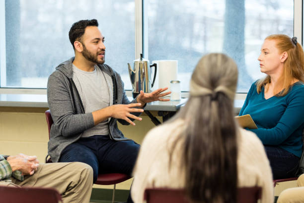 istock Serious therapist listens as young man shares with group 1487328383