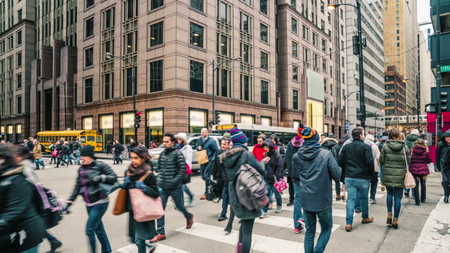 Time lapse of Crowd pedestrian and tourist walking and crossing intersection crosswalk with traffic jam among train station and modern buildings of Downtown Chicago, Illinois, United States