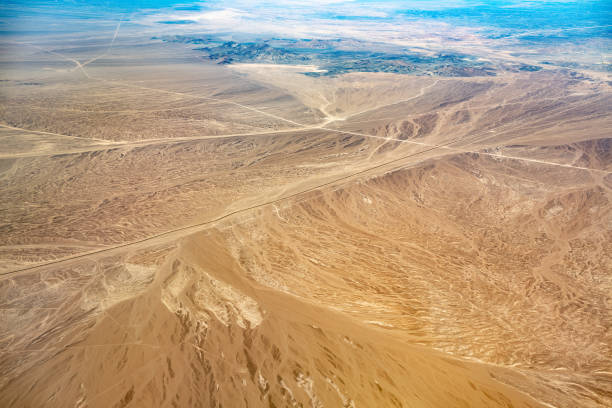 Nazca desert and panamerican highway seen from above, under the wing of a Nasca Lines airplane. Peru.