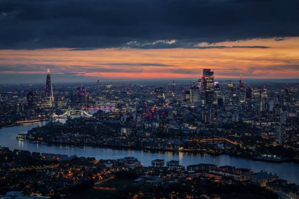 Wide aerial panorama of the illuminated London skyline during evening Wide aerial panorama of the illuminated London skyline during evening, England, with River Thames leading into the city london england stock pictures, royalty-free photos & images