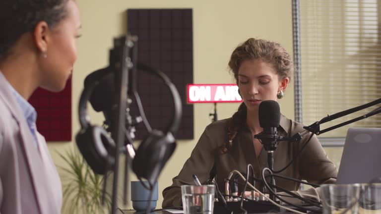 Female Radio Host Interviewing Guest in Podcast Studio