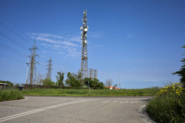 晴れた日に変電所にフィールドと無線アンテナがある田舎道の交差点 - stoplight agriculture blue cloud ストックフォトと画像