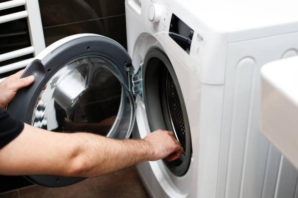 istock Man opens washing machine in bathroom at home 1487337102