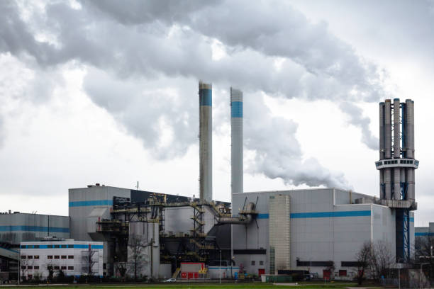 istock An industrial plant with chimneys from which thick smoke comes out into a cloudy sky. Environmental pollution by industry. 1487342941