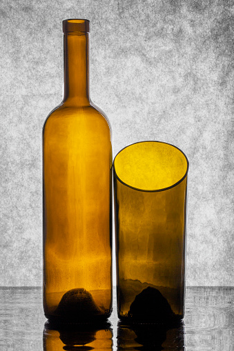 Bottle and part of the bottle on a gray background