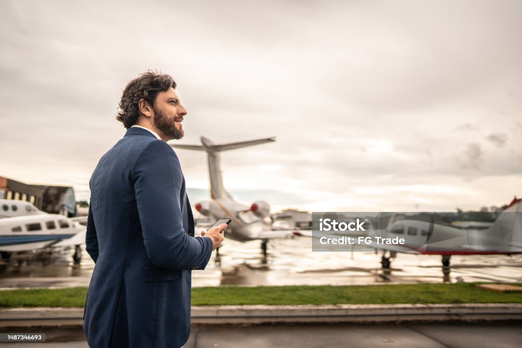 Mid adult man contemplating in the airport hangar Businessman Stock Photo