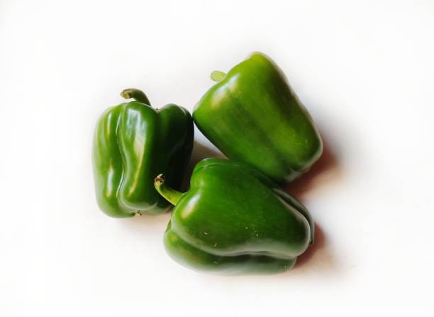 Fresh green bell pepper (capsicum) Fresh green bell pepper (capsicum) on a white background. basket healthy eating vegetarian food studio shot stock pictures, royalty-free photos & images