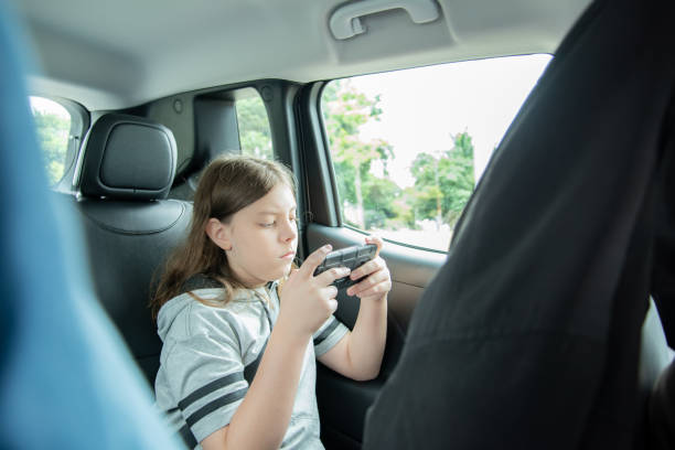 istock Child in passenger seat using cell phone 1487349574