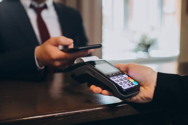 istock A businessman pays a bill for a hotel room through a smartphone using NFC technology. 1487351091