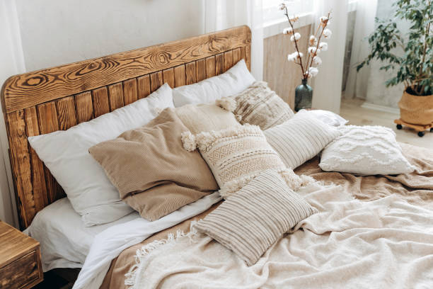 istock Cozy rustic bedroom with boho ethnic decor. Large windows. Double wooden bed with many pillows and handmade textiles. Wooden furniture. Nobody 1487351943