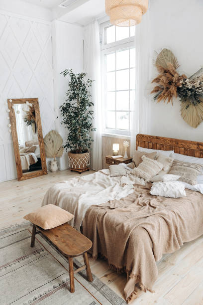 istock Cozy rustic bedroom with boho ethnic decor. Bright spacious apartment with large windows. Wooden furniture. Large mirror. Handmade textile. Plants in the interior. Nobody 1487352182