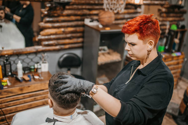 istock Young female barber and a young client in a barbershop 1487353742