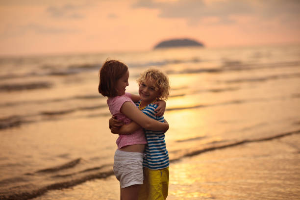 istock Child playing on ocean beach. Kid at sunset sea. 1487353751