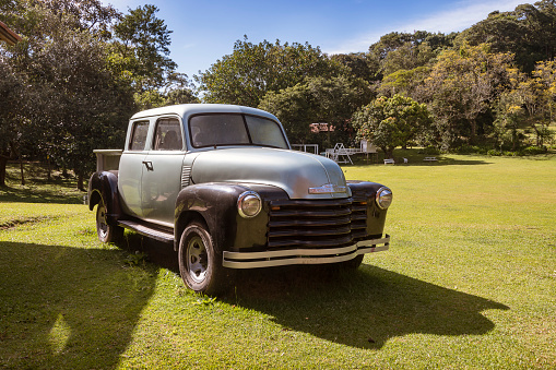 Aldeia Parque Pousada Hotel, Sao Roque, Brazil. April 25, 2023. Old two tone Chevrolet pickup truck parked on lawn in farm field.