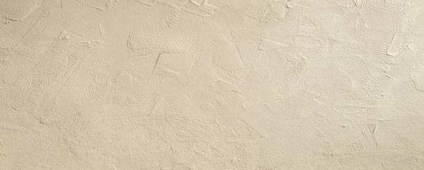istock Light beige rough grainy stone or plastered wall texture background 1487355262