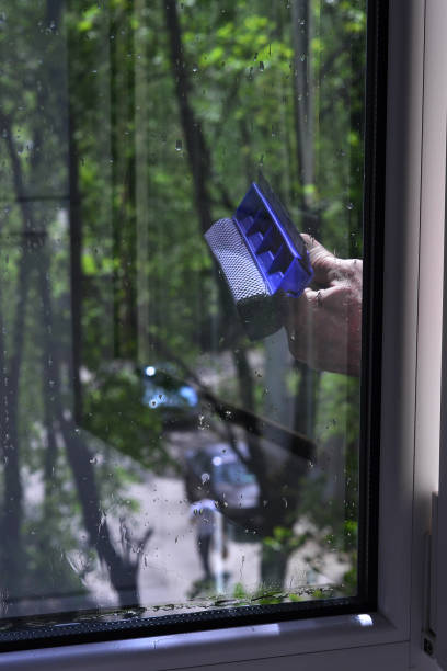 istock A man is holding a brush outside the window 1487355282