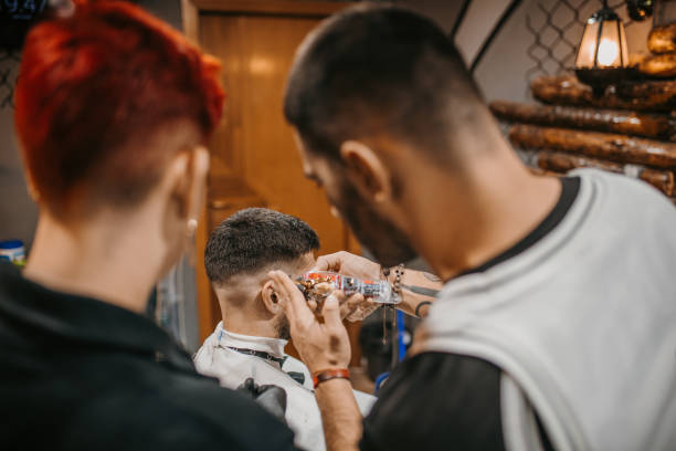 istock A young female barber in training in a barbershop 1487357392